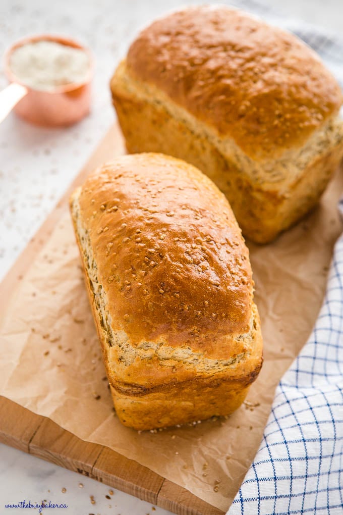 2 loaves of whole grain bread on wood cutting board