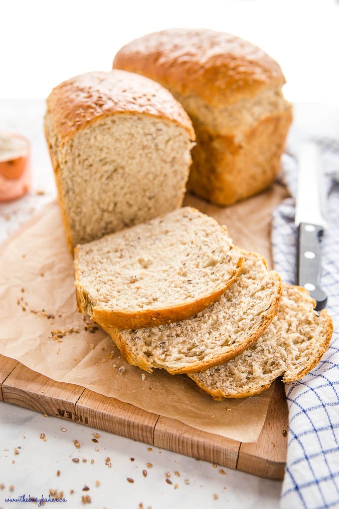 2 loaves of whole grain bread sliced on a wooden cutting board