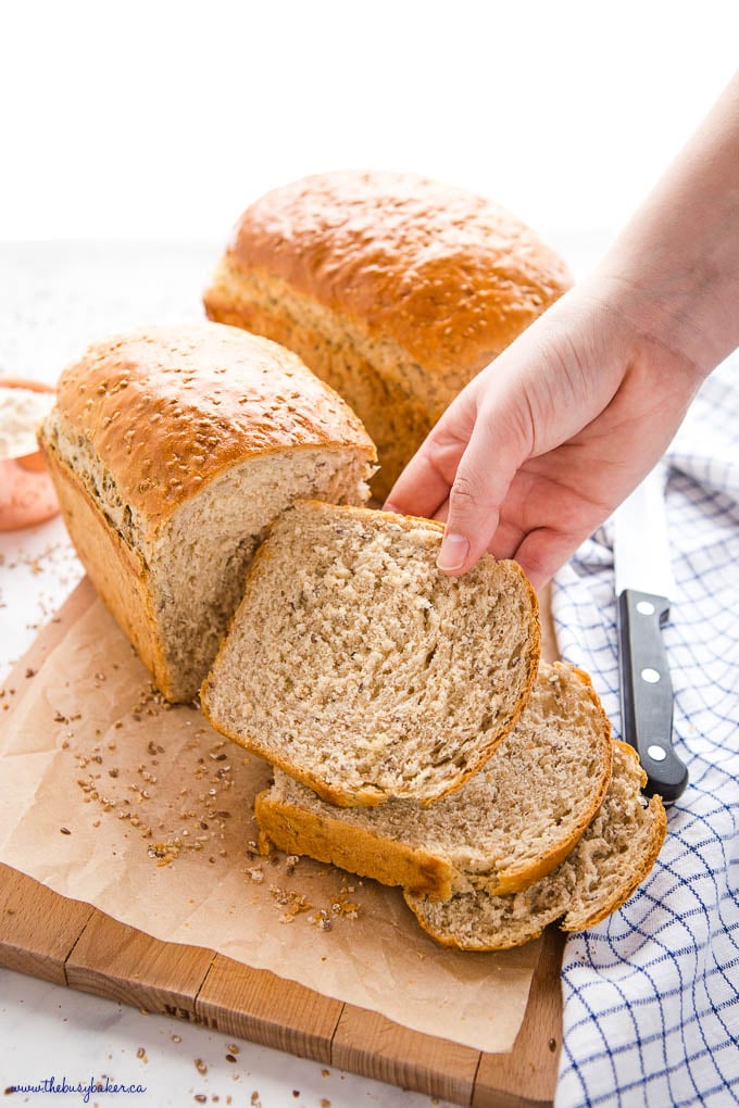 hand reaching for slice of whole grain bread