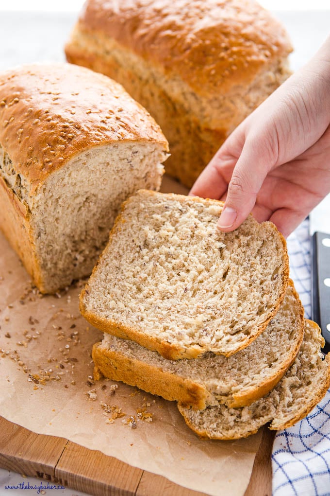 hand reaching for a slice of whole grain bread