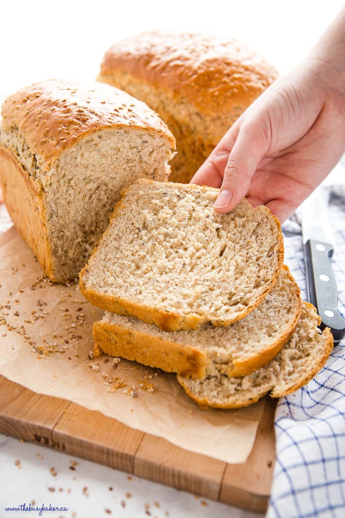 hand reaching for slice of whole grain bread
