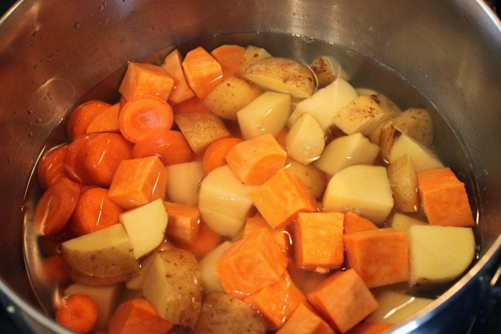 root vegetables cooking in a pot of water
