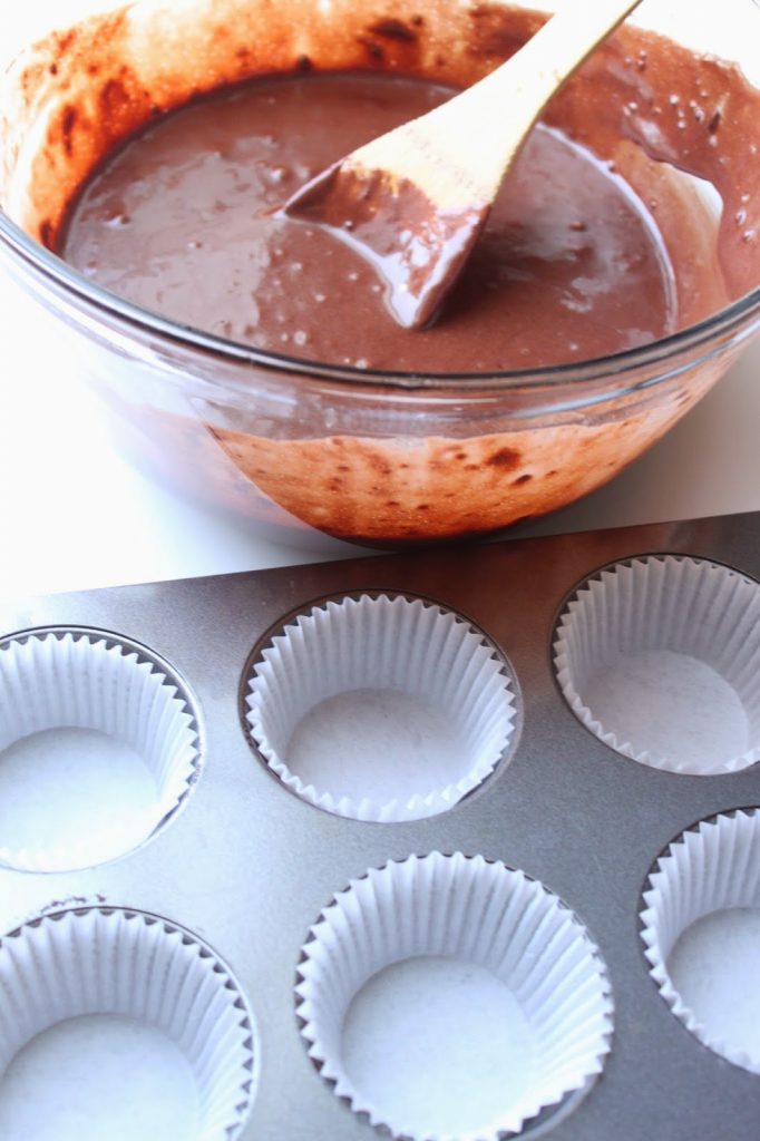 stirring chocolate cupcakes batter in a bowl