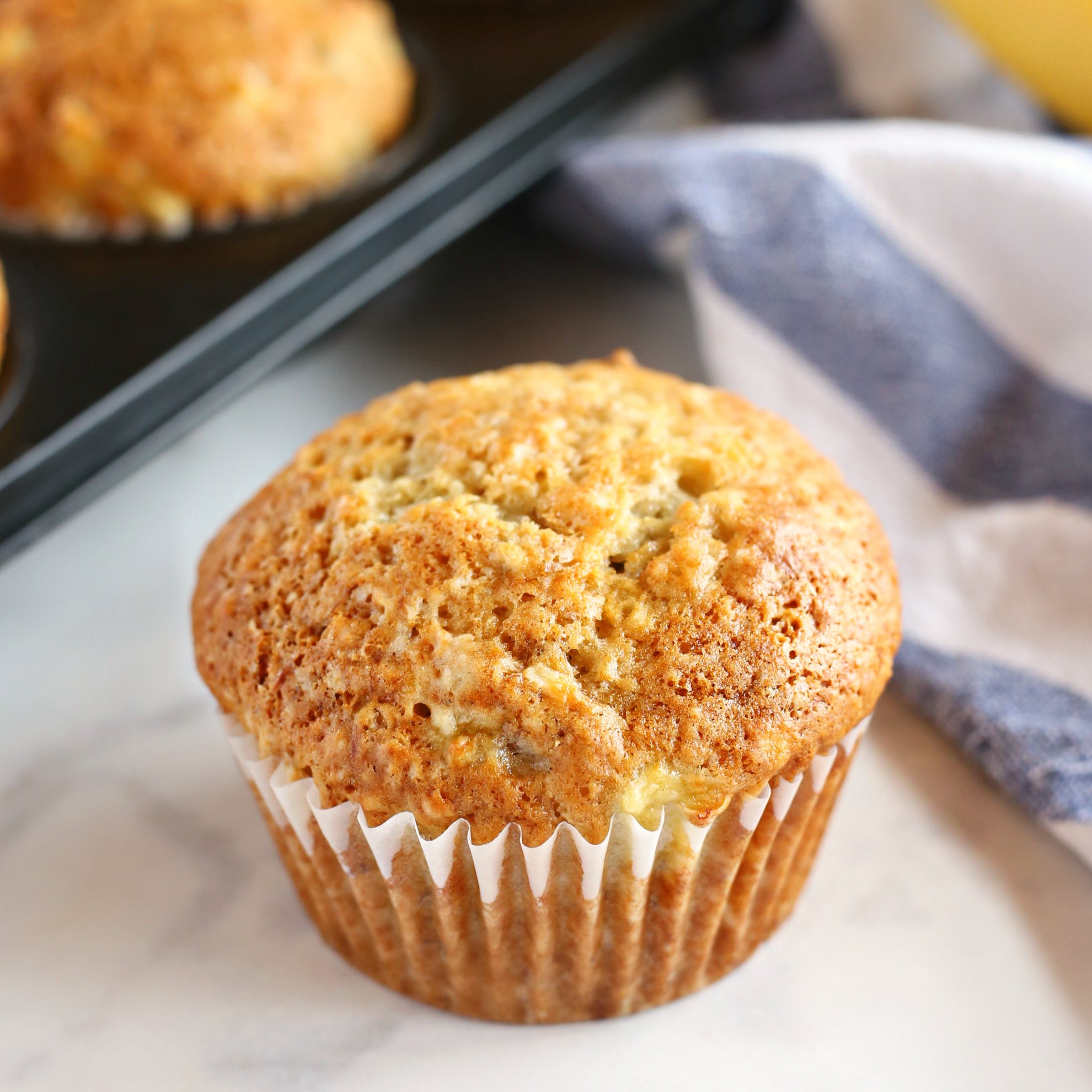 twelve cooked mini banana muffins in a tin