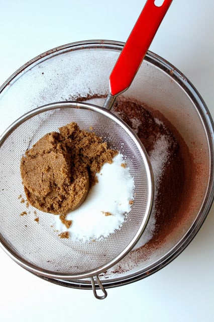 sifting chocolate cake ingredients into a bowl