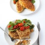 plated dinner of chicken Milanese with roasted tomatoes and spinach