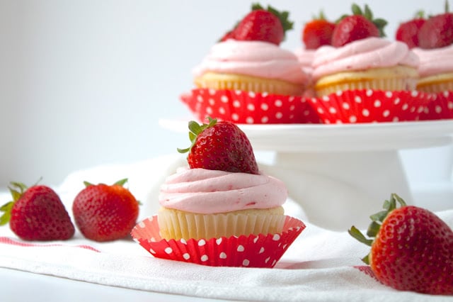 Strawberry Cupcakes with Fresh Strawberry Buttercream are the perfect summer dessert, packed with fresh strawberries. You'll love this easy cupcakes recipe! #cupcakes #recipe #strawberries #desserts fresh strawberry cupcakes garnished with strawberry buttercream and whole strawberries
