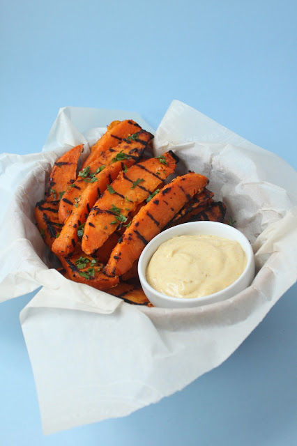 parchment paper lined basket of grilled sweet potatoes wedges