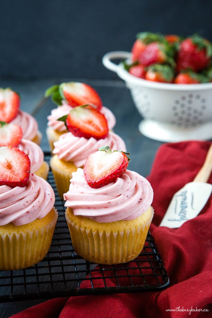 strawberry cupcakes with pink frosting and a strawberry on top