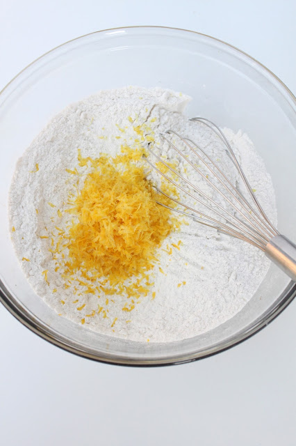 mixing bowl with flour and lemon zest being whisked together