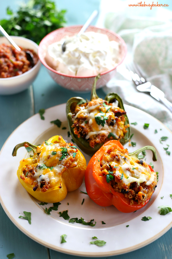 These Mexican-Style Quinoa Stuffed Peppers are the perfect healthy family meal that's naturally gluten-free! These stuffed peppers are bursting with Mexican flavours and packed with veggies and fibre and topped with cheese for a wholesome meal the whole family will love! Recipe from thebusybaker.ca! #mexicanstuffedpeppers #quinoapeppers #glutenfree #glutenfreemeal