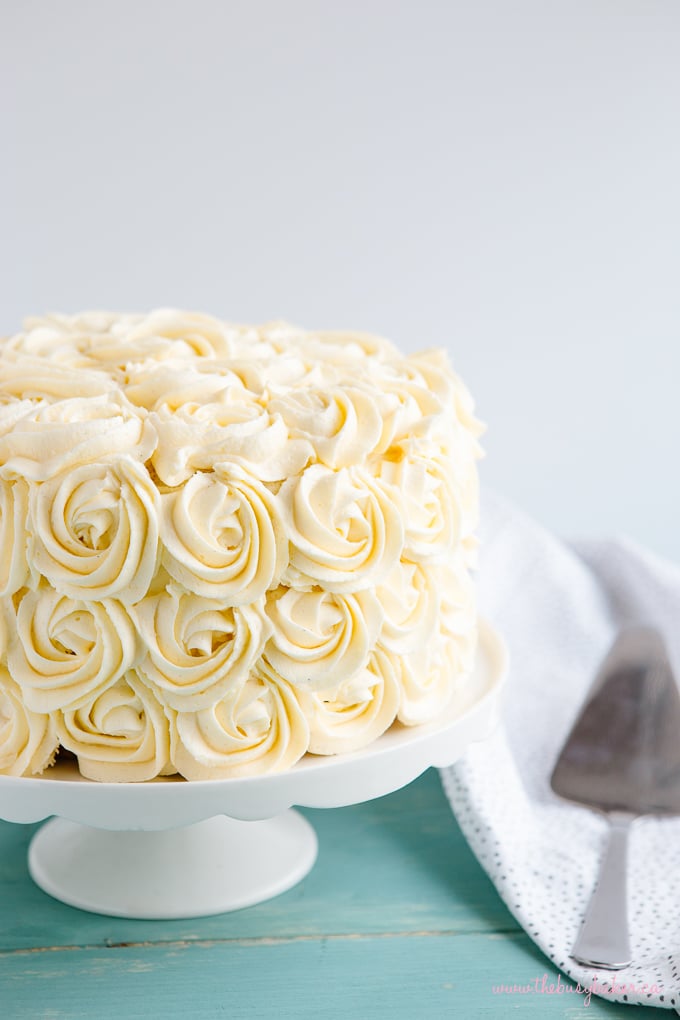 Best Ever Vanilla Bean White Cake with frosting roses on cake stand