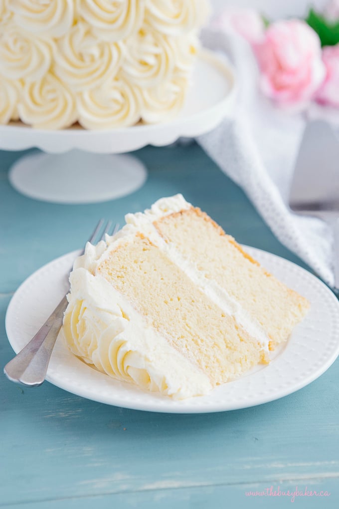 Best Ever Vanilla Bean White Cake slice on white plate with fork