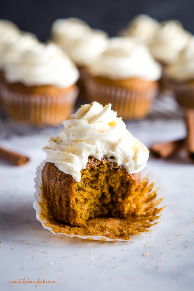 bite out of pumpkin spice cupcake with cream cheese frosting