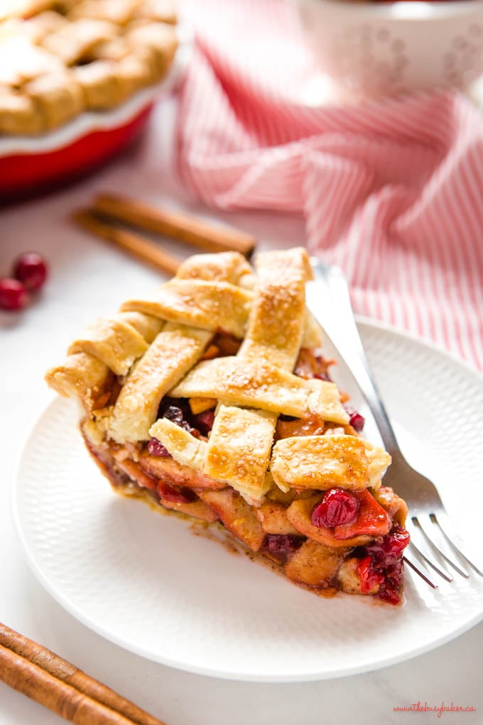 slice of cranberry apple pie on white plate with fork