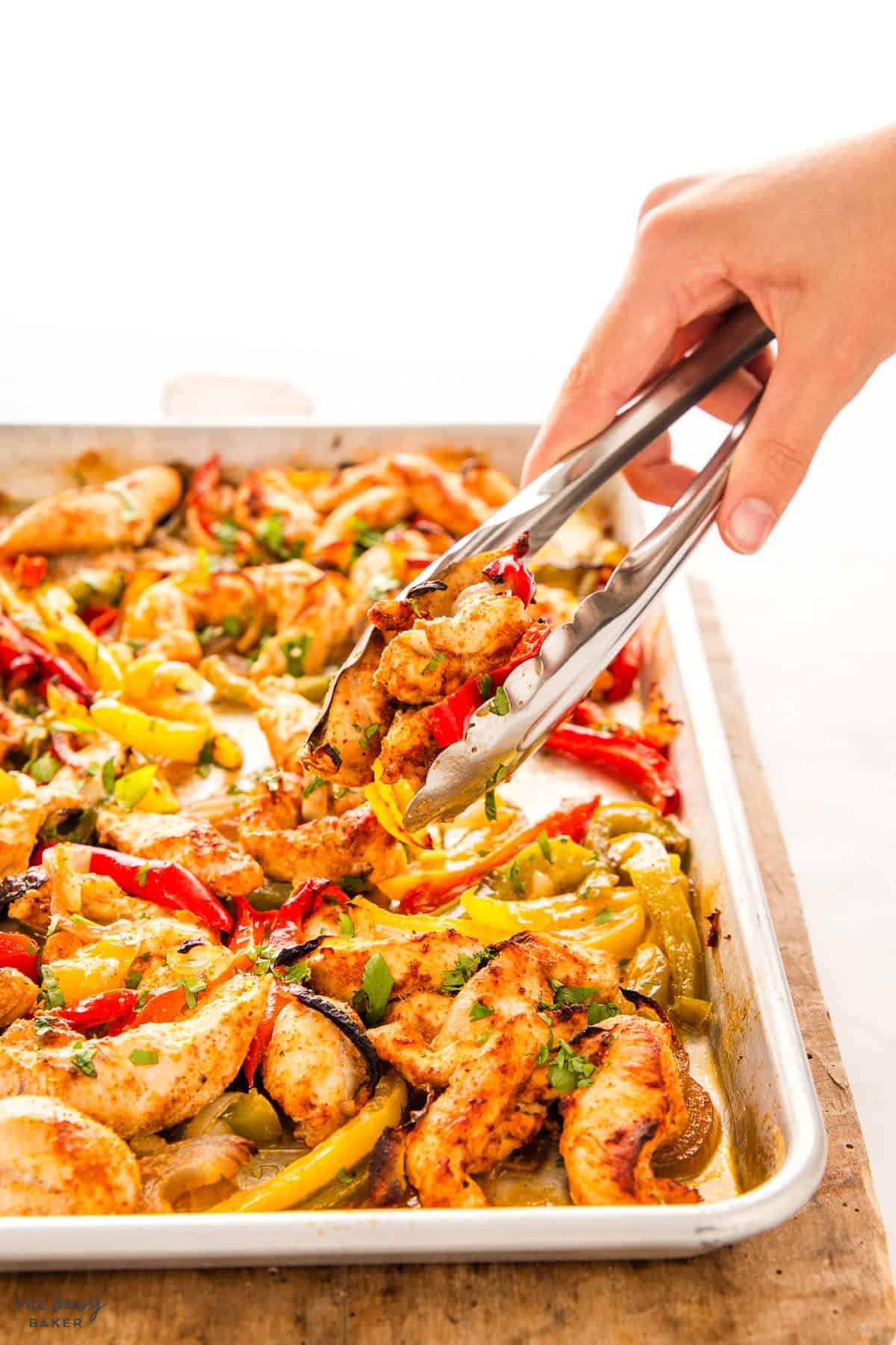 hand serving chicken fajitas with tongs