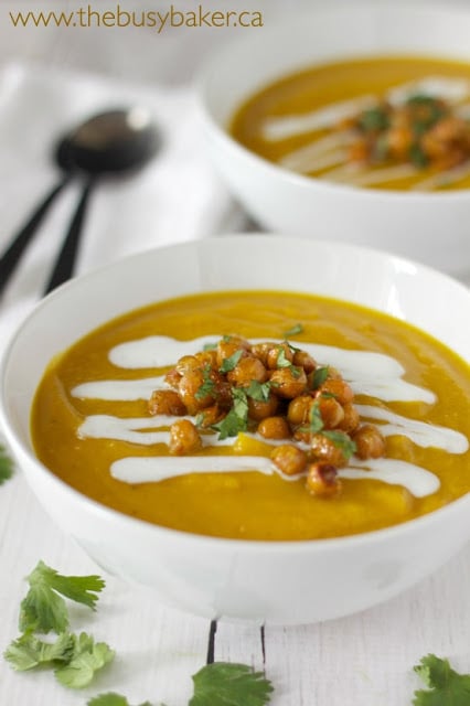 a bowl of vegan butternut squash soup garnished with coconut cream and dry roasted chickpeas