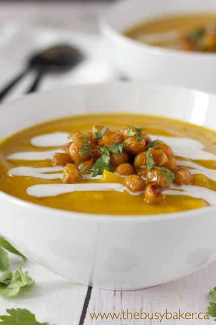 bowl of butternut squash red lentil soup topped with roasted chickpeas and coconut cream