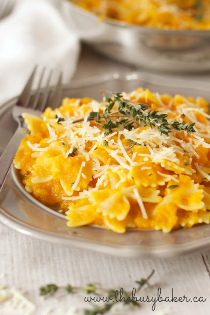 butternut squash pasta dinner garnished with shredded Parmesan cheese and fresh thyme