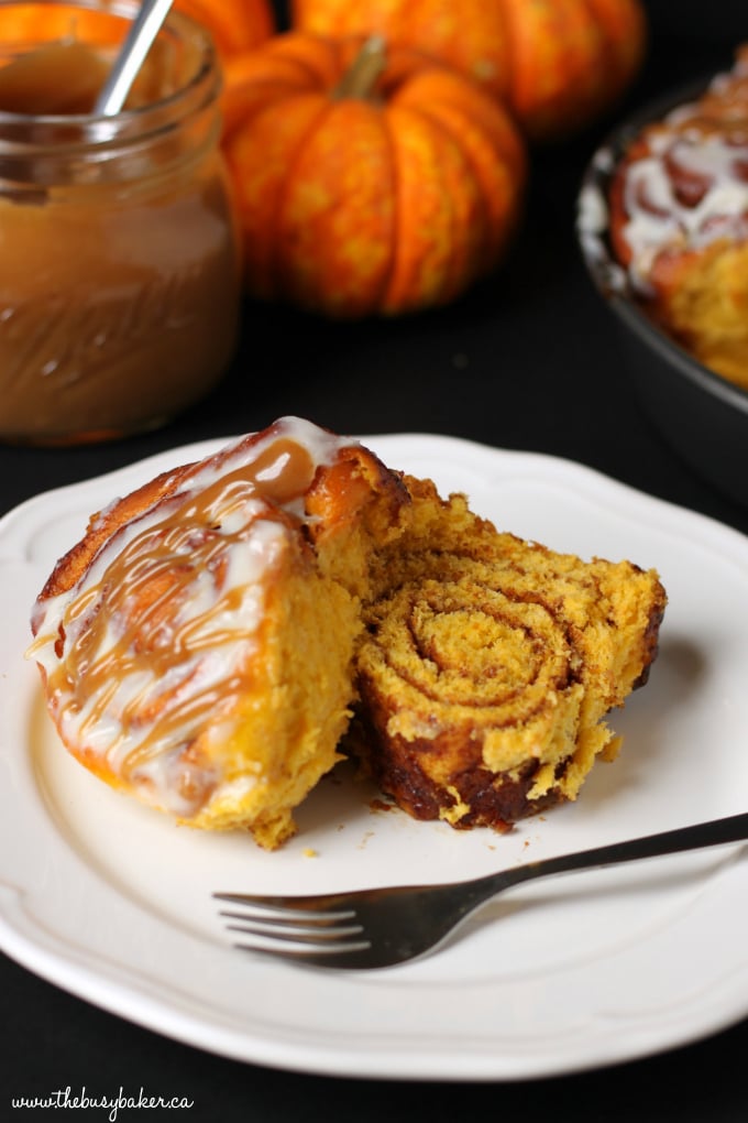 soft pumpkin spice cinnamon roll on a white plate