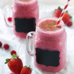 two cranberry smoothies with fresh strawberries