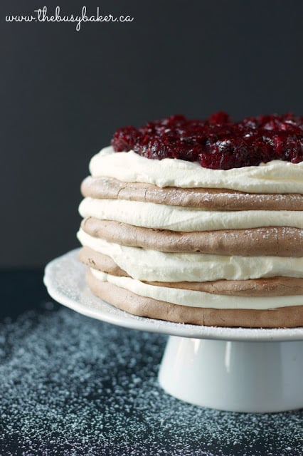 meringue torte cake layered with whipped cream and cranberries