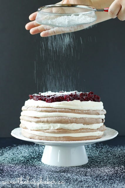 sifting powdered sugar over a meringue cake