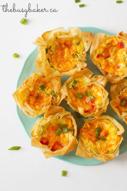 a green platter of roasted red pepper quiche cups appetizers