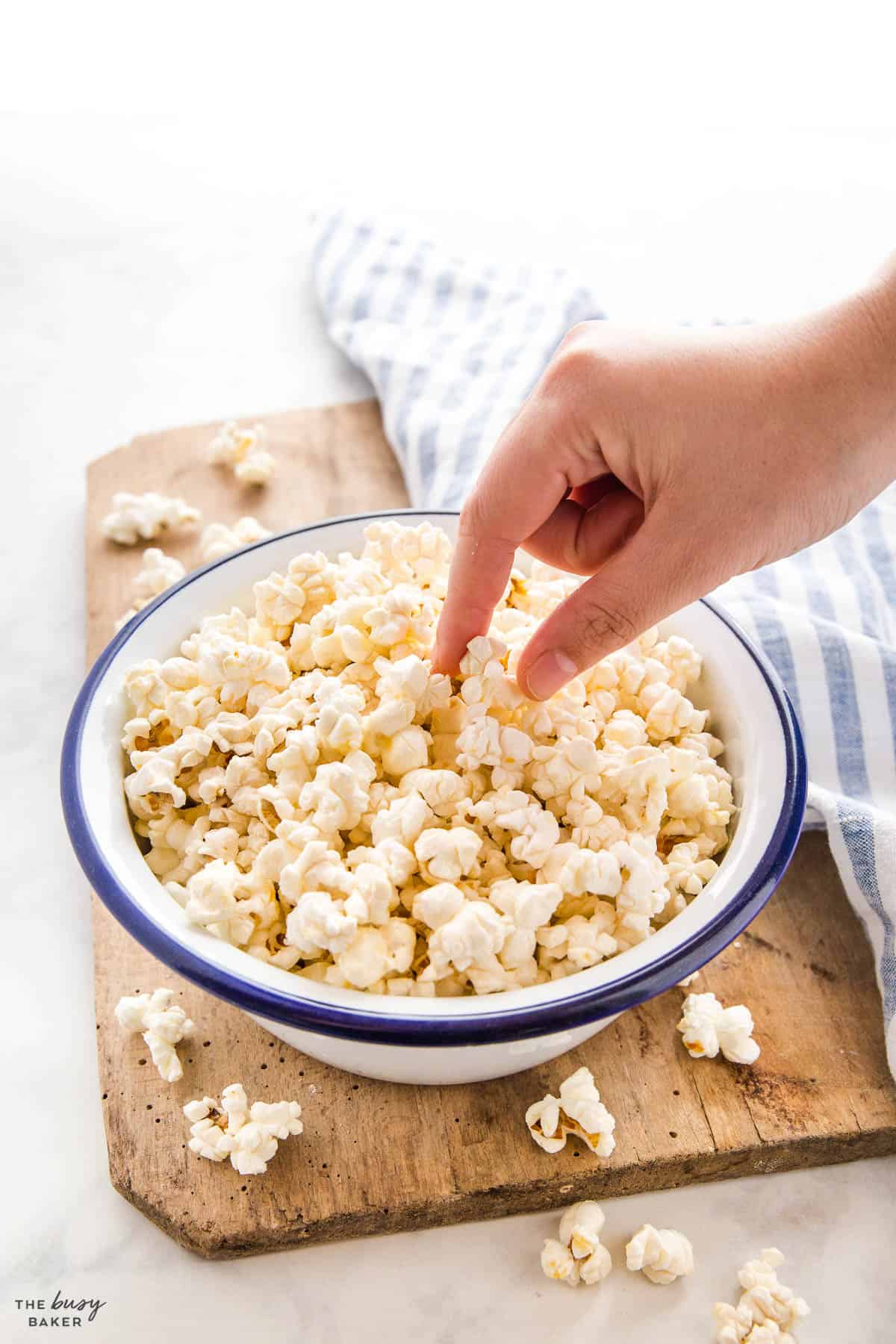 hand reaching for popcorn in a bowl