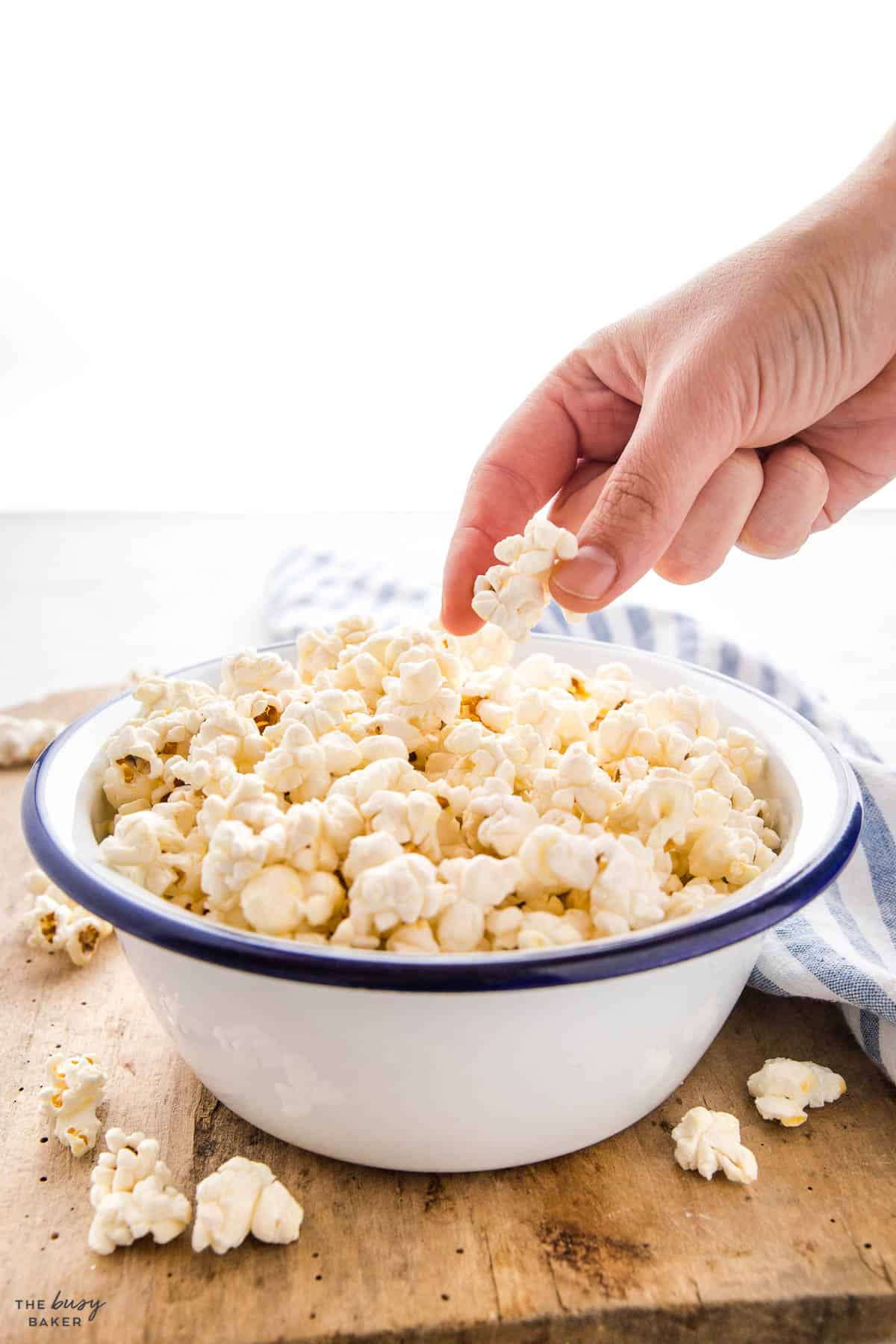 hand reaching for a kernel of kettle corn popcorn