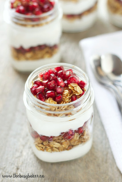 fresh pomegranate arils layered in between and on top of a Greek yogurt and homemade granola parfait