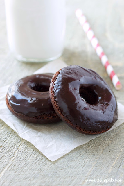 These Healthier Double Chocolate Baked Donuts are the perfect low-fat sweet treat to satisfy those chocolate cravings! Made with less sugar and fat than a traditional donut and baked to perfection with a chocolatey glaze, these Healthier Double Chocolate Baked Donuts are easy to make and totally delicious! Recipe from thebusybaker.ca! #healthydonuts #easybakeddonuts #donutrecipe #chocolatedonutrecipe