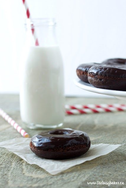 These Healthier Double Chocolate Baked Donuts are the perfect low-fat sweet treat to satisfy those chocolate cravings! Made with less sugar and fat than a traditional donut and baked to perfection with a chocolatey glaze, these Healthier Double Chocolate Baked Donuts are easy to make and totally delicious! Recipe from thebusybaker.ca! #healthydonuts #easybakeddonuts #donutrecipe #chocolatedonutrecipe