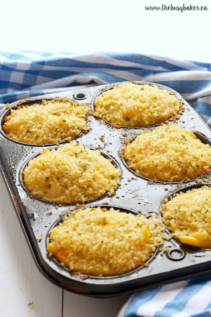 muffin tin full of baked mac and cheese muffins