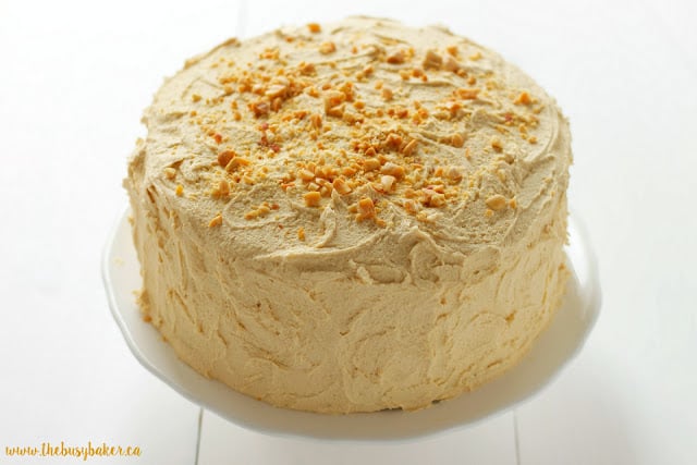 homemade banana cake topped with peanut butter frosting and crushed roasted peanuts