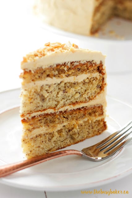 a slice of banana cake with fluffy peanut butter frosting in between the layers and on top