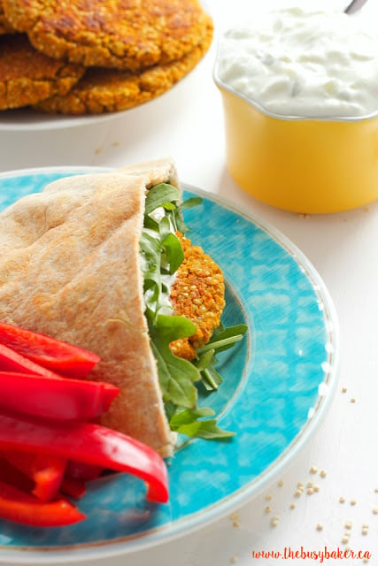 quinoa burgers on a plate and one in a pita pocket with arugula and tzatziki sauce