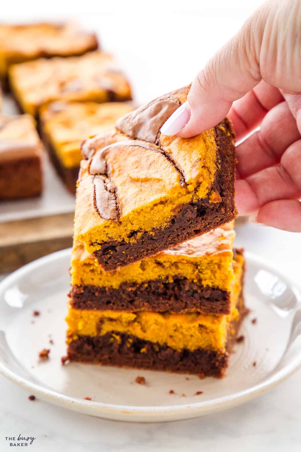 hand reaching for a pumpkin brownie