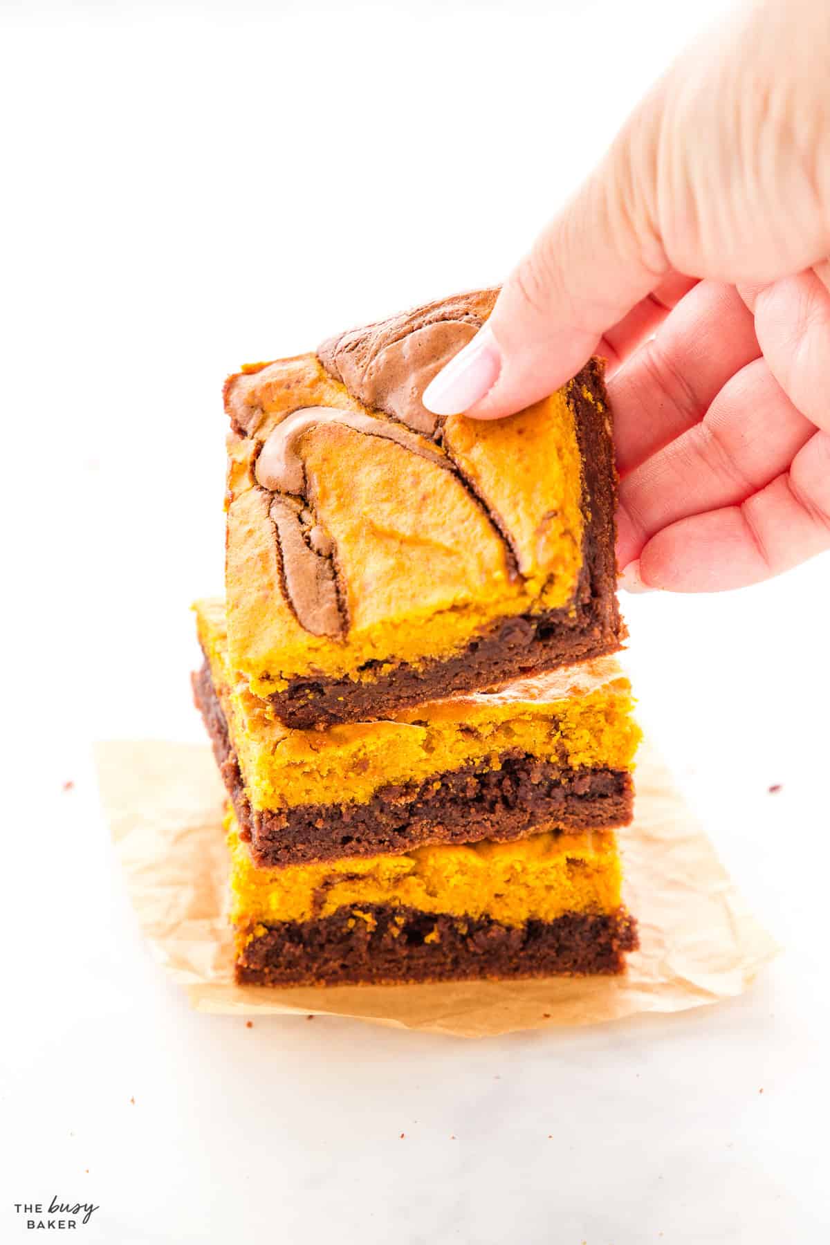 hand reaching for a pumpkin brownie