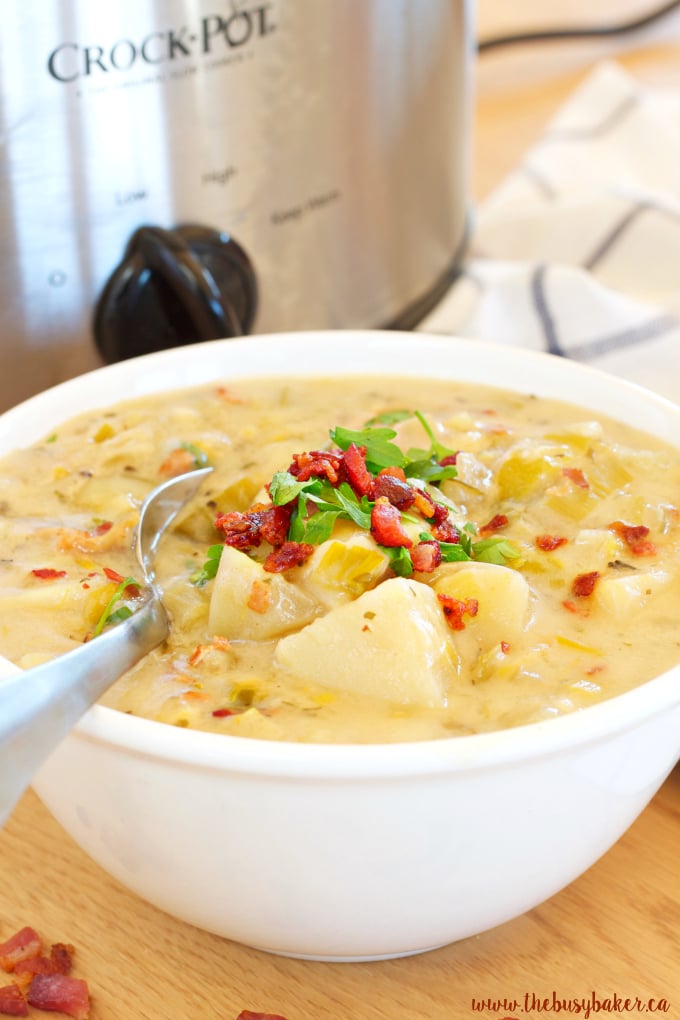 close up of potato and leek soup topped with bacon in a white bowl