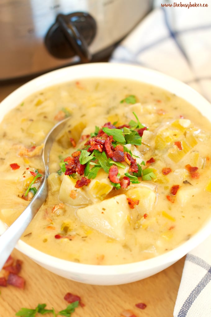 bacon, leek, potato chunks in a white bowl with spoon.