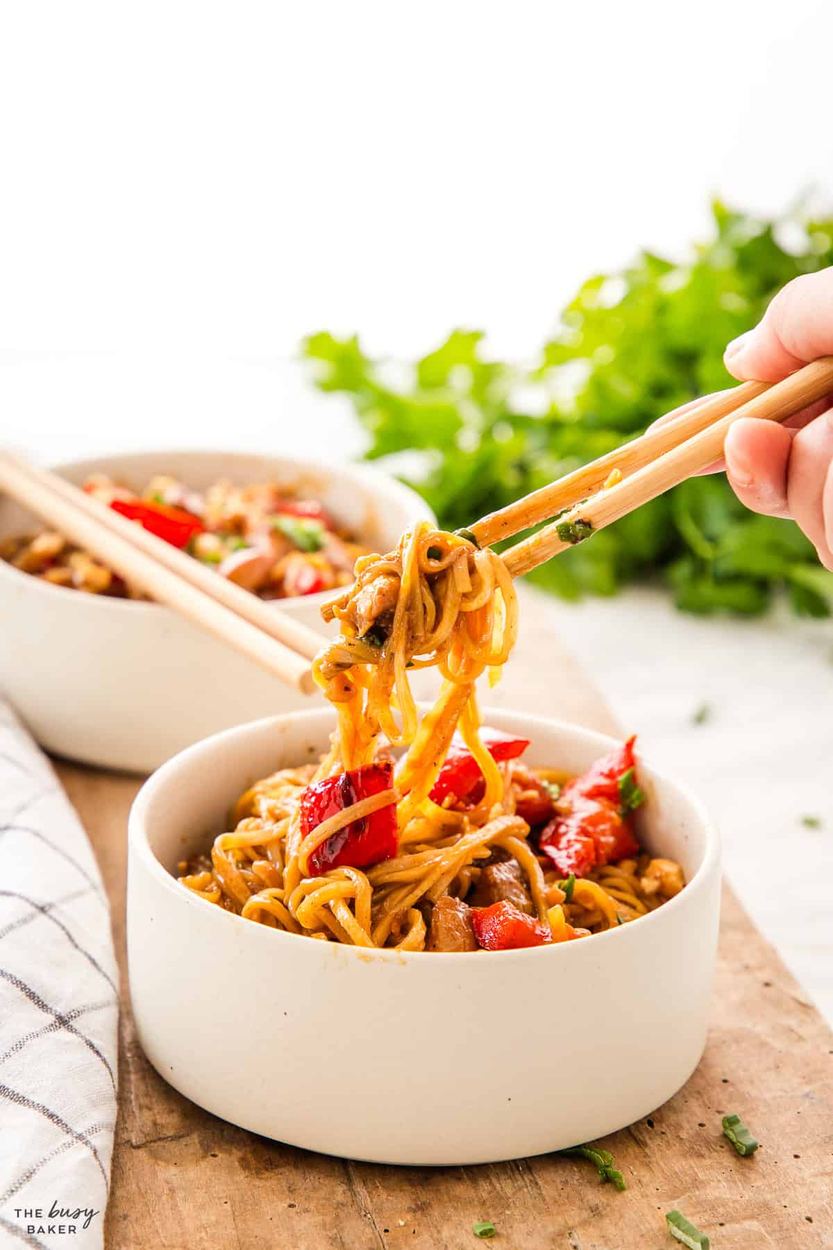 white bowl of kung pao chicken with chopsticks