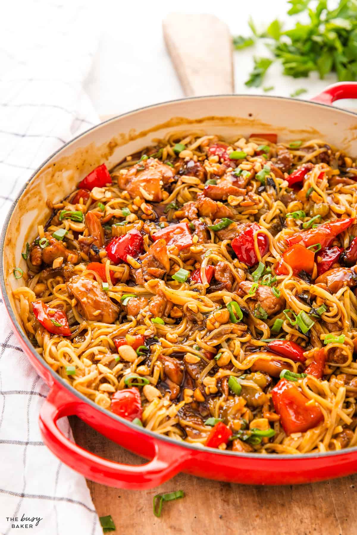 red cast iron pan with rice noodles and chicken and veggies