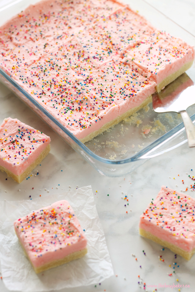 These Soft and Chewy Sugar Cookie Bars are the perfect kid-friendly dessert made with a tender sugar cookie base topped with fluffy frosting and sprinkles! Recipe from thebusybaker.ca!