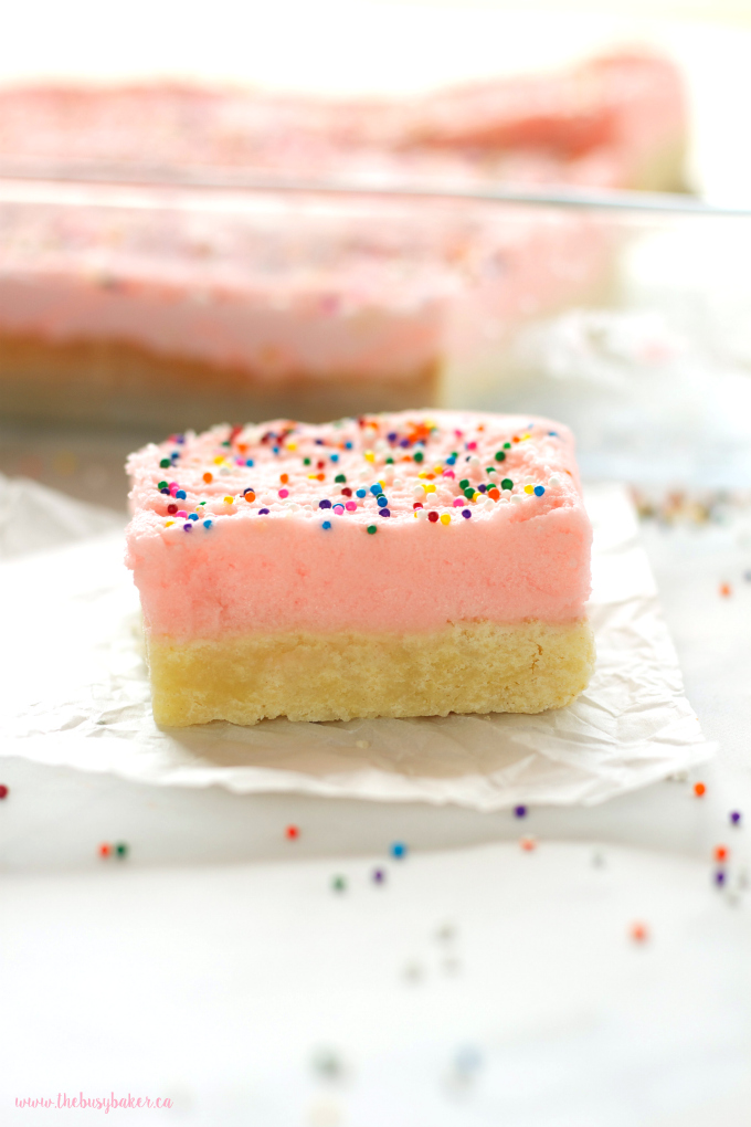 These Soft and Chewy Sugar Cookie Bars are the perfect kid-friendly dessert made with a tender sugar cookie base topped with fluffy frosting and sprinkles! Recipe from thebusybaker.ca!