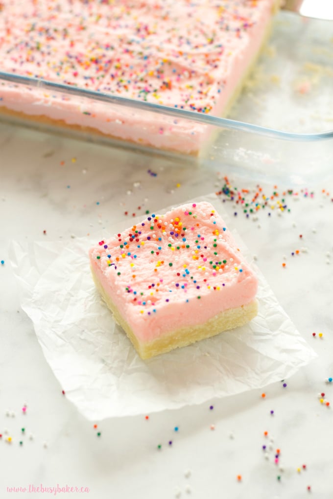 These Soft and Chewy Sugar Cookie Bars are the perfect kid-friendly dessert made with a tender sugar cookie base topped with fluffy frosting and sprinkles! Recipe from thebusybaker.ca!