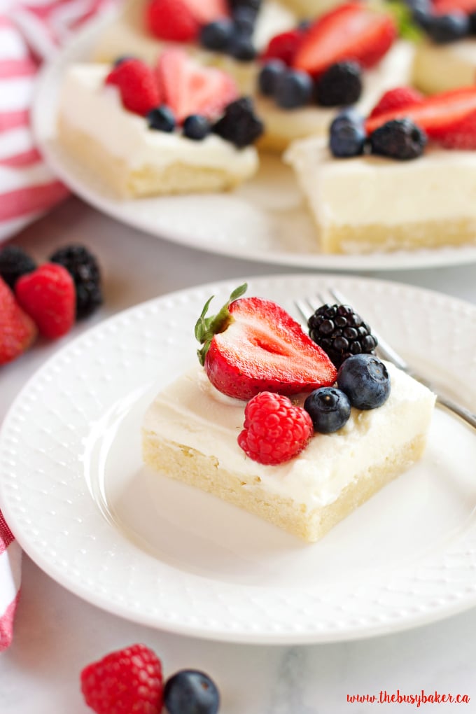 These Berry Cheesecake Sugar Cookie Bars make the perfect dessert for spring and summer featuring a cookie base, creamy cheesecake and fresh berries! Recipe from thebusybaker.ca!