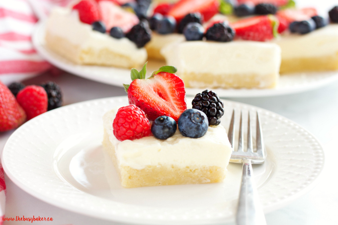 These Berry Cheesecake Sugar Cookie Bars make the perfect dessert for spring and summer featuring a cookie base, creamy cheesecake and fresh berries! Recipe from thebusybaker.ca!