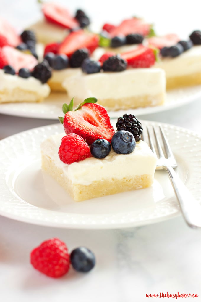 These Berry Cheesecake Sugar Cookie Bars make the perfect dessert for spring and summer featuring a cookie base, creamy cheesecake and fresh berries! Recipe from thebusybaker.ca!