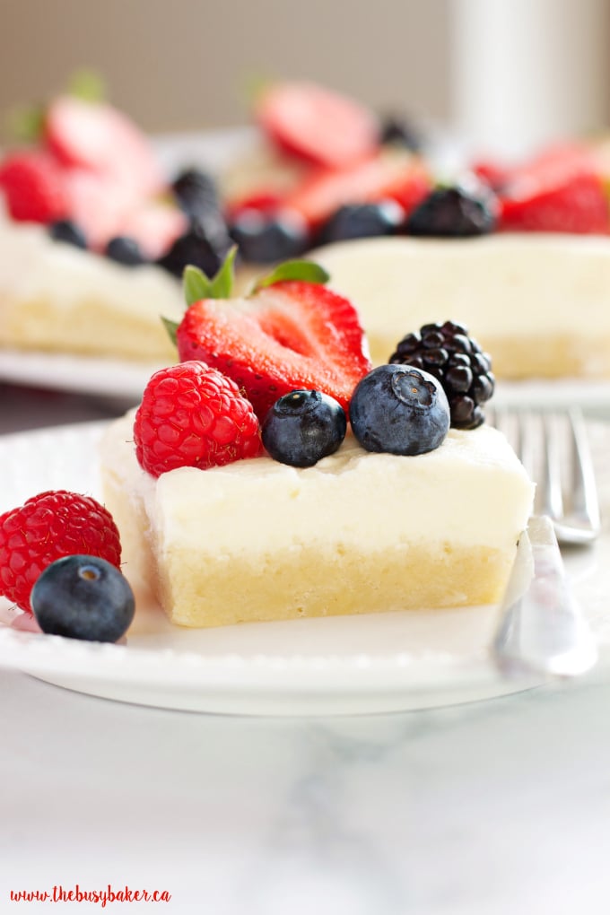 These Berry Cheesecake Sugar Cookie Bars make the perfect dessert for spring and summer featuring a cookie base, creamy cheesecake and fresh berries! Recipe from thebusybaker.ca!